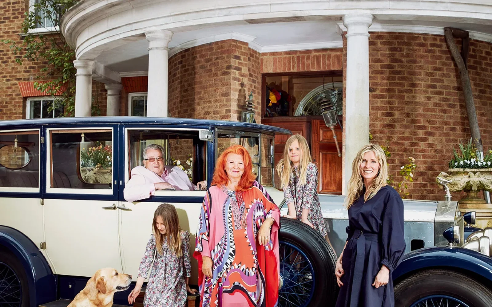 SIR WILLIAM (IN HIS VINTAGE ROLLS-ROYCE) AND LADY MCALPINE, WITH, FROM LEFT, HER GRANDDAUGHTERS MATILDA AND POPPY AND HER DAUGHTER VICKY PLUS BORIS THE LABRADOR AND PUGS ALICE AND ALGIE. Mark Cocksedge